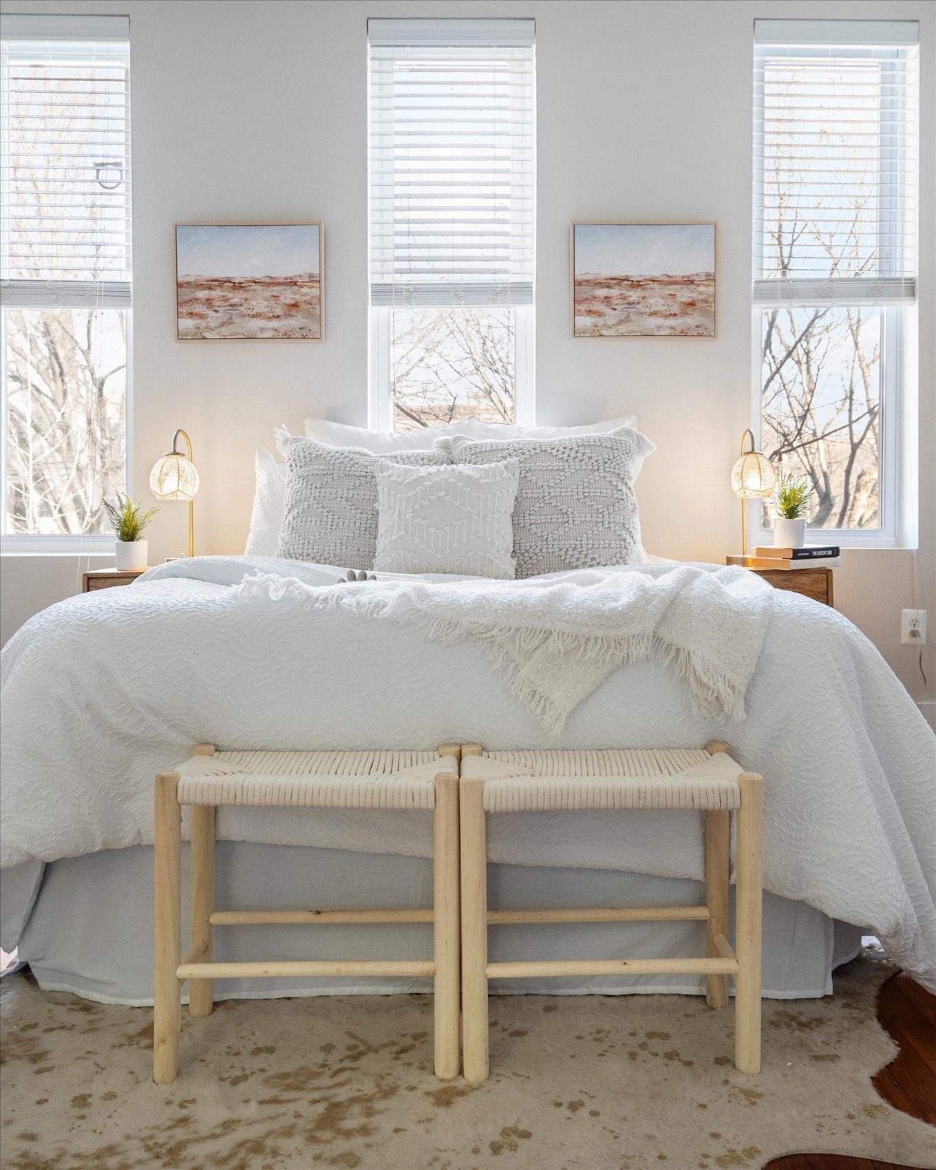A bedroom with a bed , two benches , and a dog.