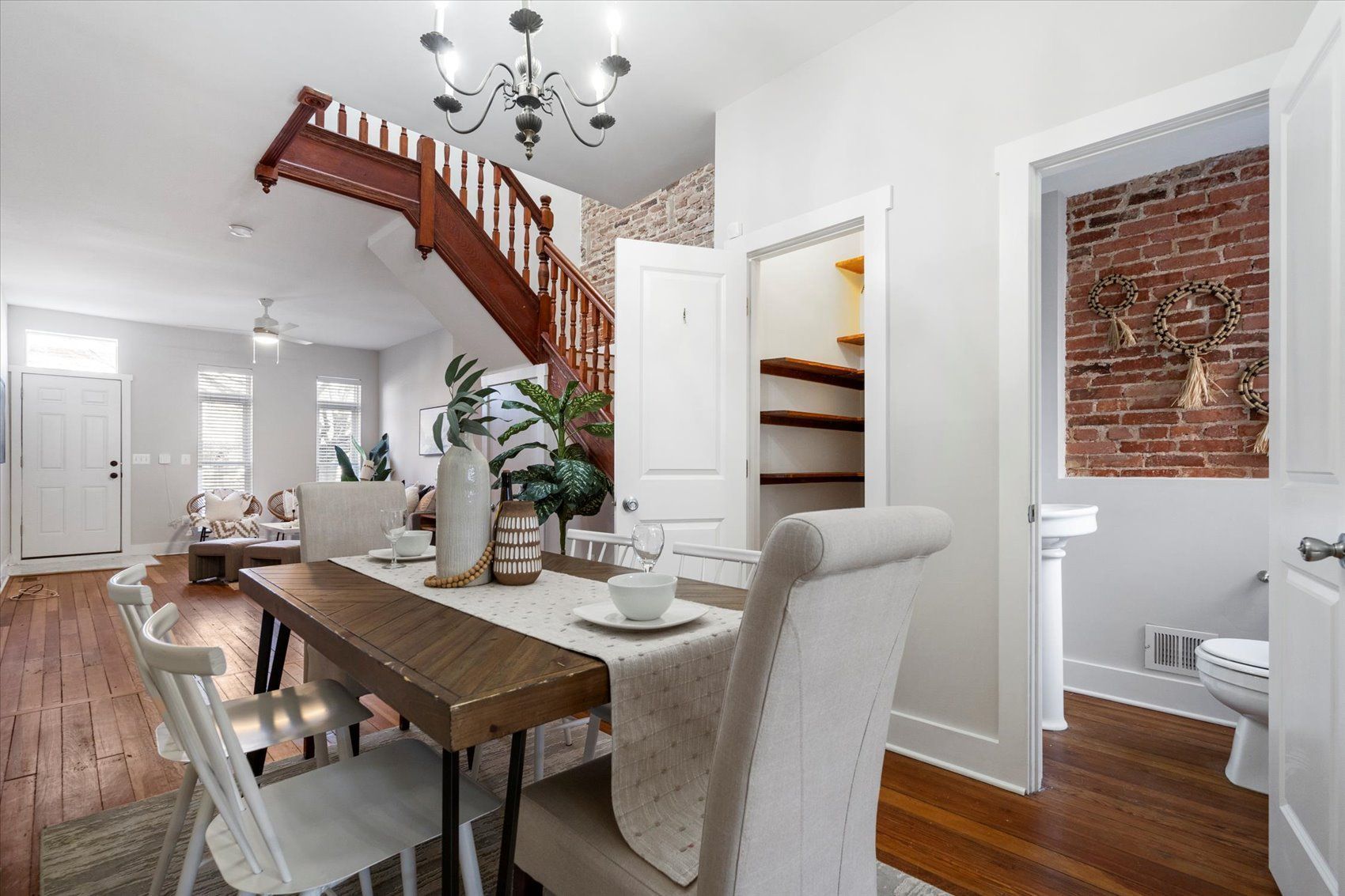 A dining room table and chairs in a house with a brick wall.