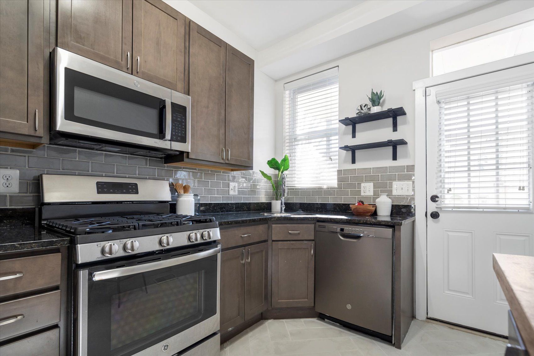 A kitchen with stainless steel appliances and wooden cabinets.