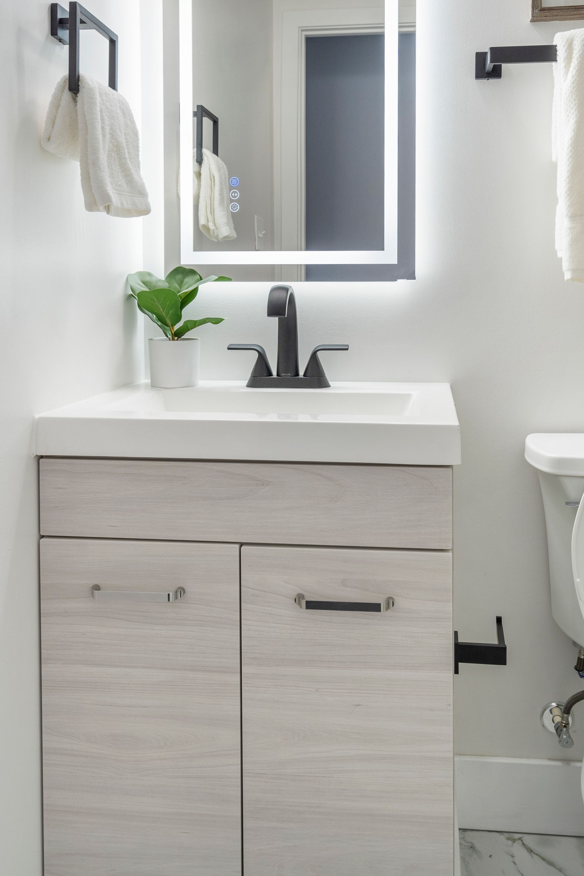 A bathroom with a sink , mirror and toilet.