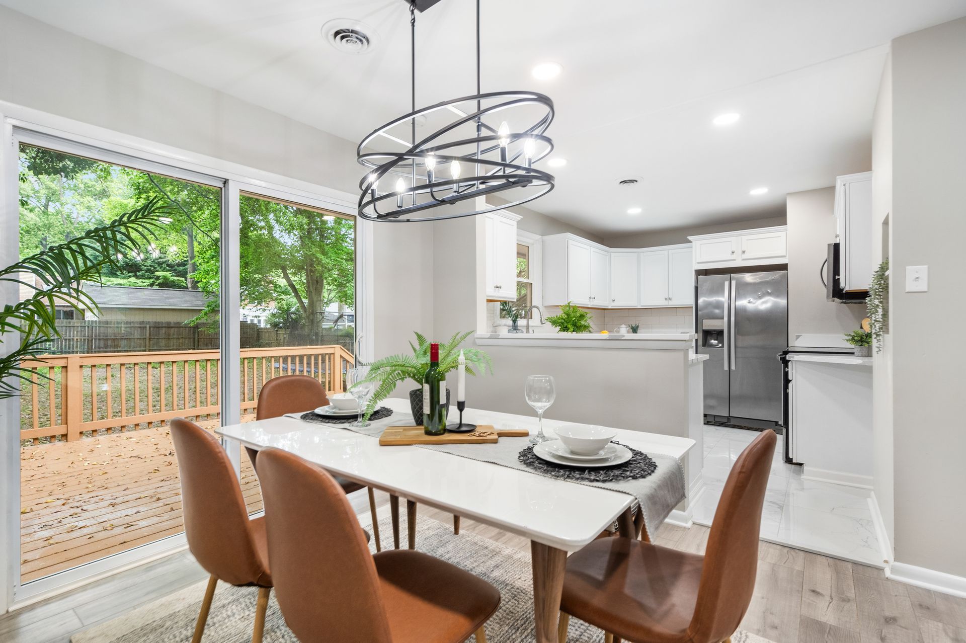 A dining room with a table and chairs and a sliding glass door leading to a deck.
