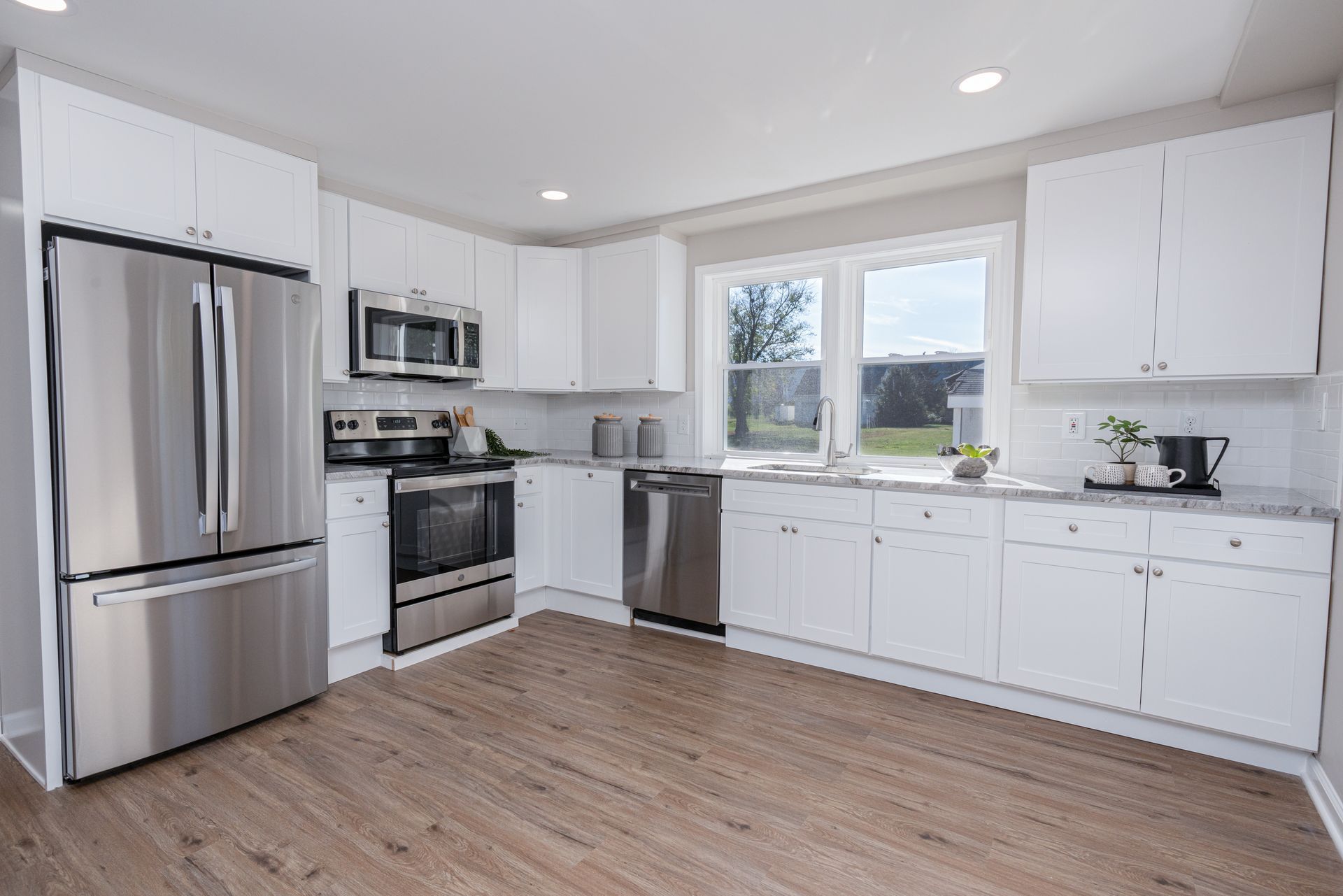 A kitchen with white cabinets and stainless steel appliances.