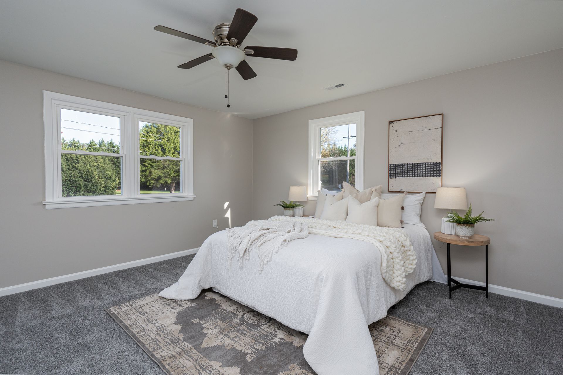 A bedroom with a bed and a ceiling fan.