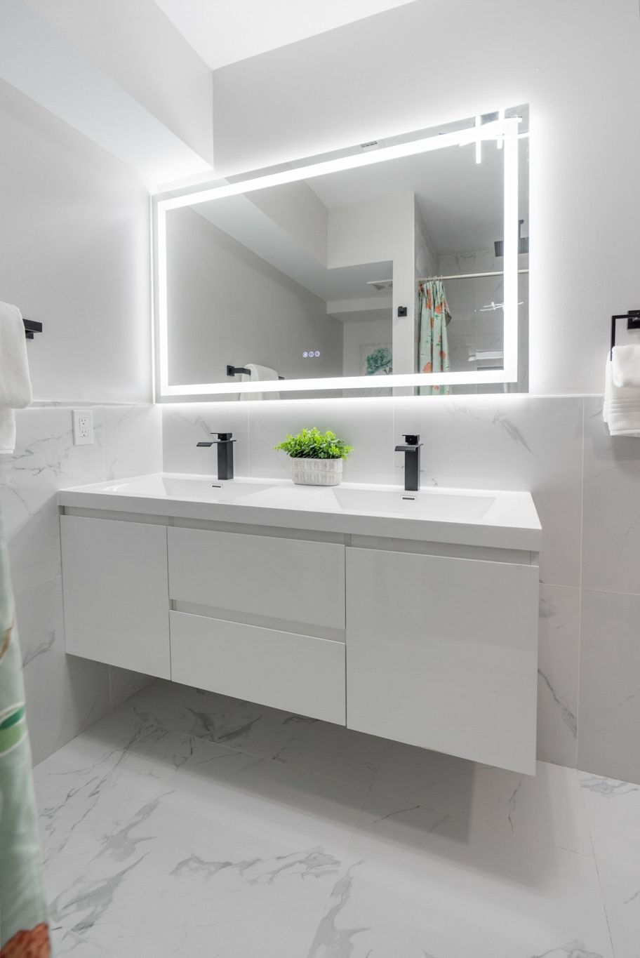 A bathroom with two sinks and a large mirror.