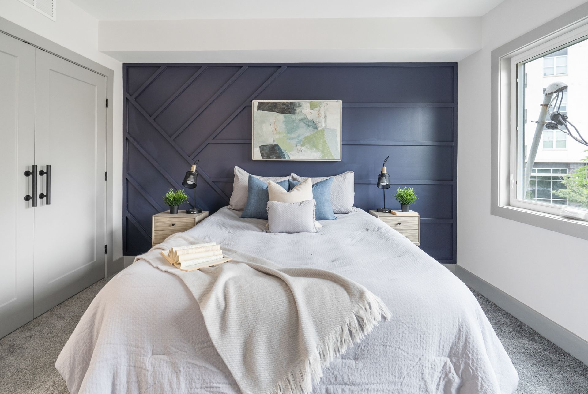 A bedroom with a bed , nightstands , and a blue wall.
