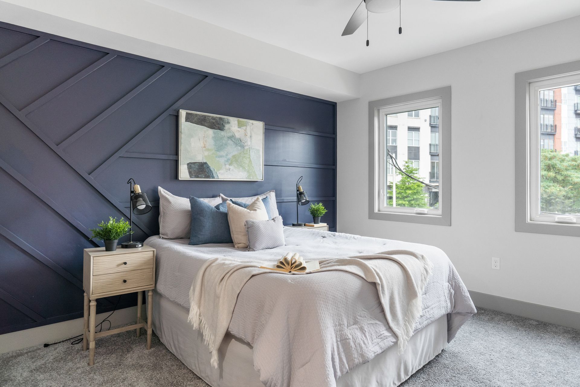 A bedroom with a bed , nightstand , and ceiling fan.