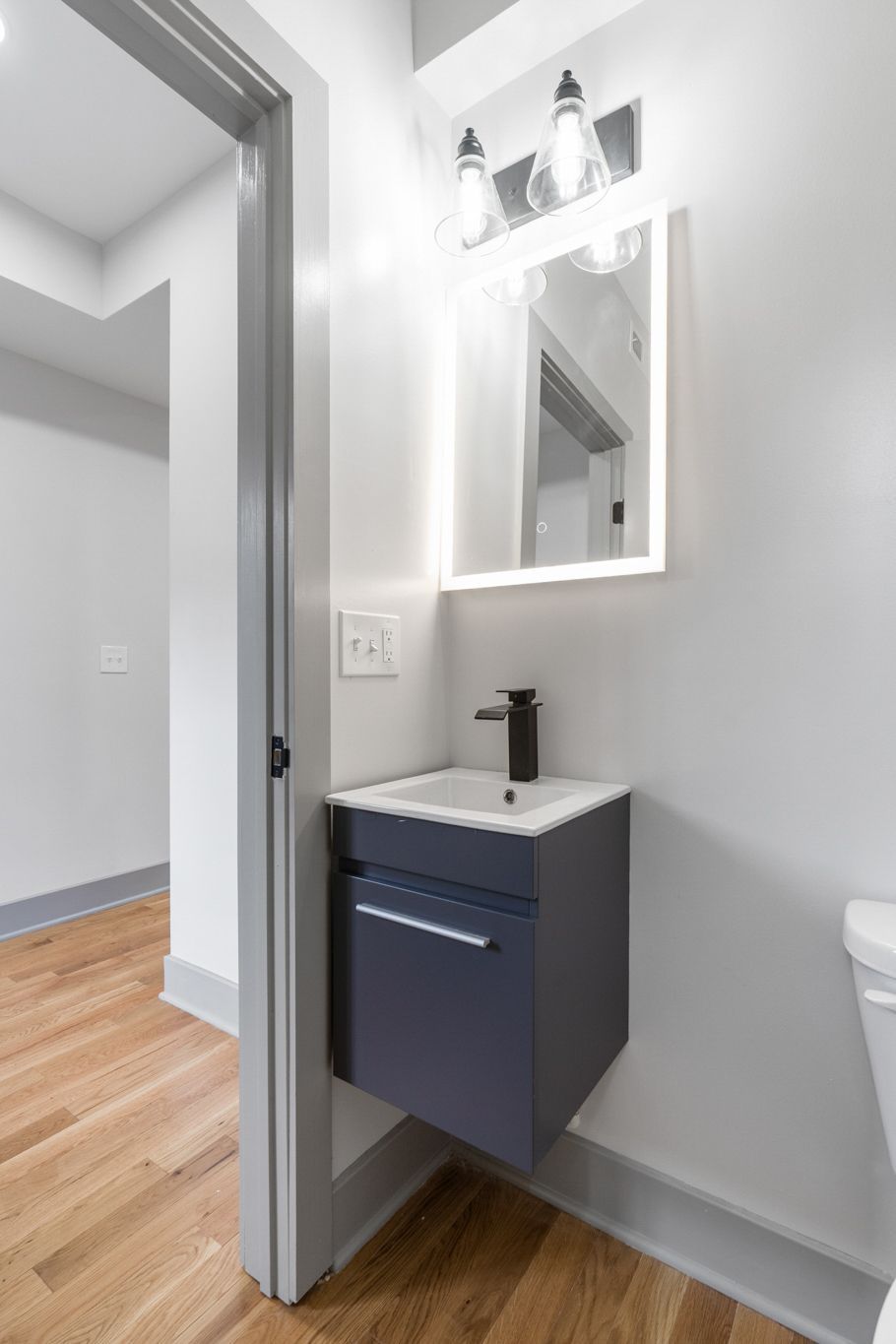 A bathroom with a sink , mirror and toilet.