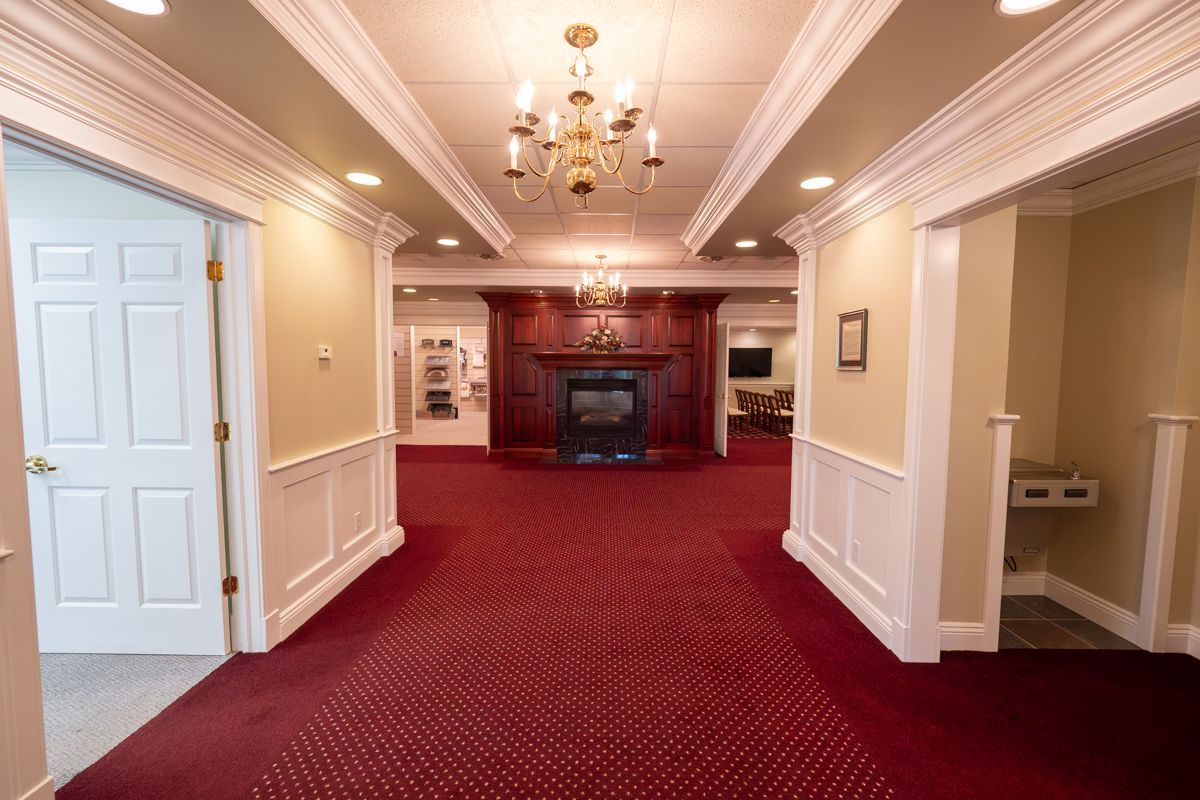 A hallway with a fireplace and a chandelier hanging from the ceiling