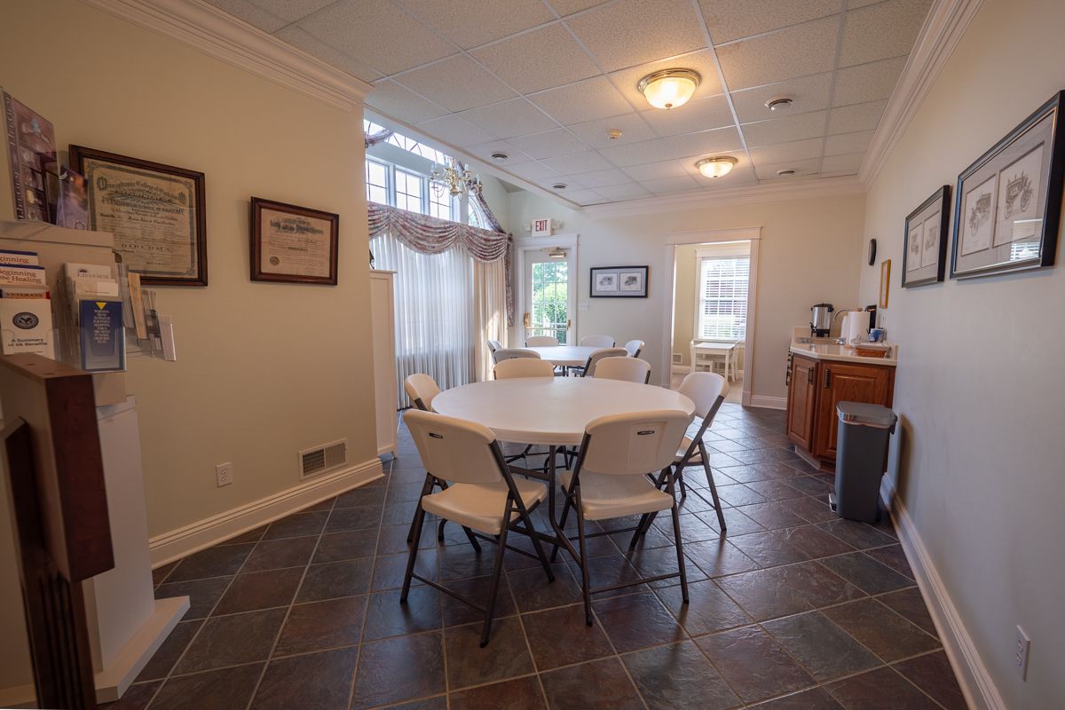 A room with a table and chairs in front of a large window.