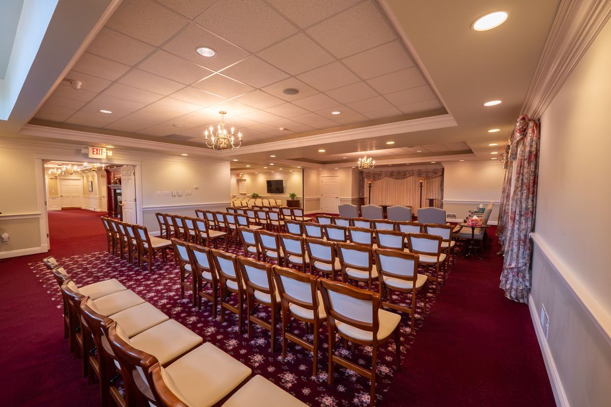A large room with rows of chairs and a chandelier.