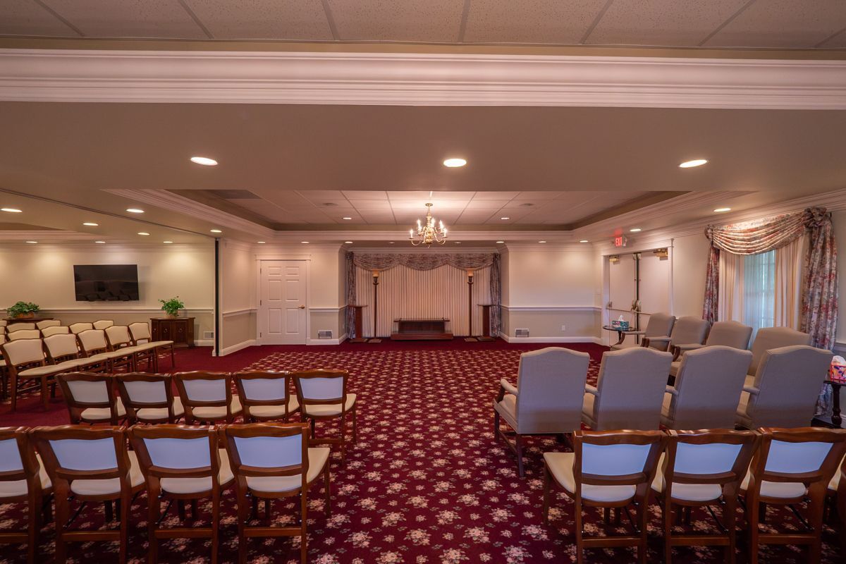 A large room with rows of chairs and a chandelier.