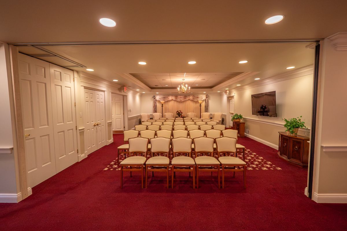 A large room with rows of chairs and a chandelier.
