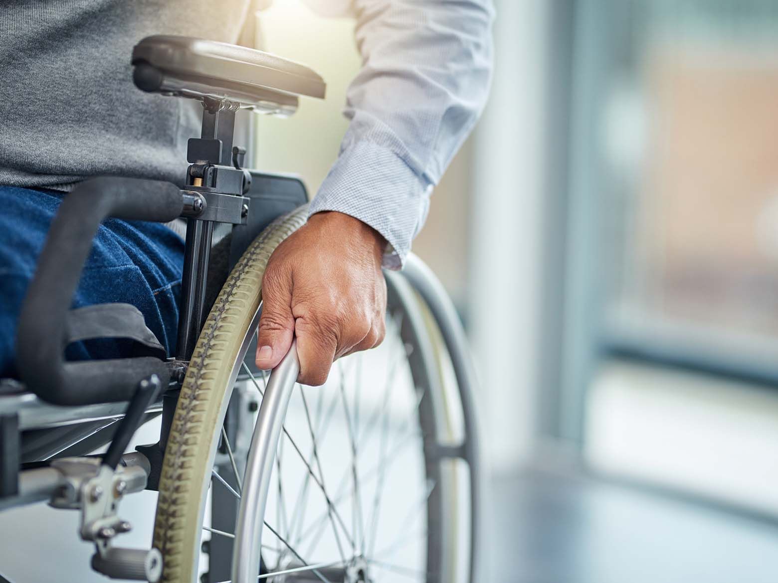 A man in a wheelchair is holding the wheel.