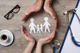 A couple of hands holding a paper cut out of a family.