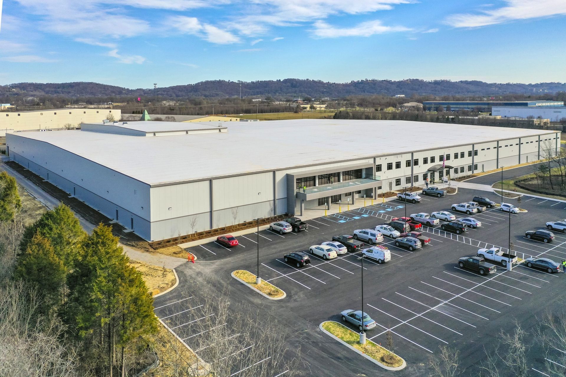 An aerial view of a large building with a parking lot in front of it.