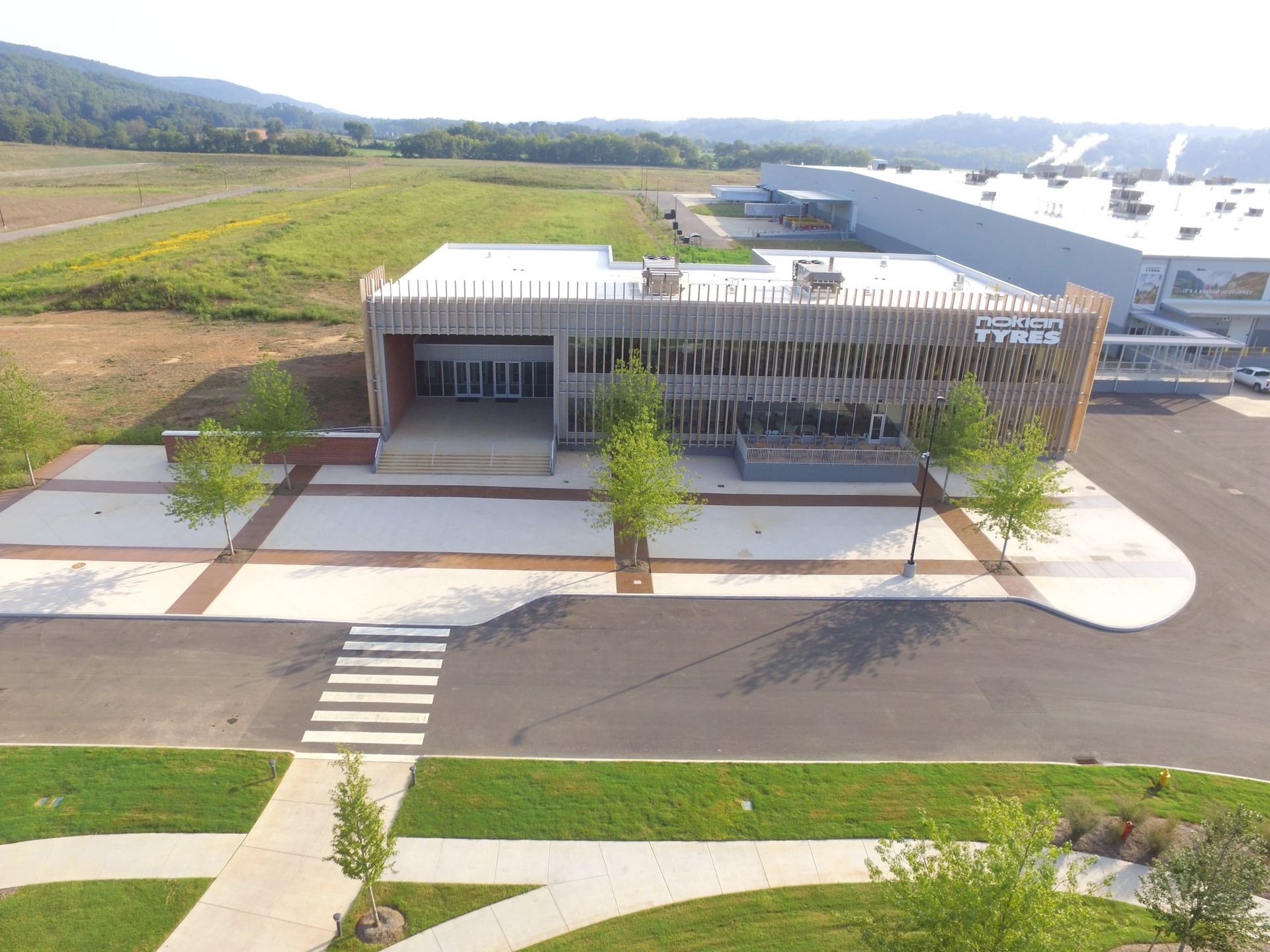 An aerial view of a building with a lot of trees in front of it.