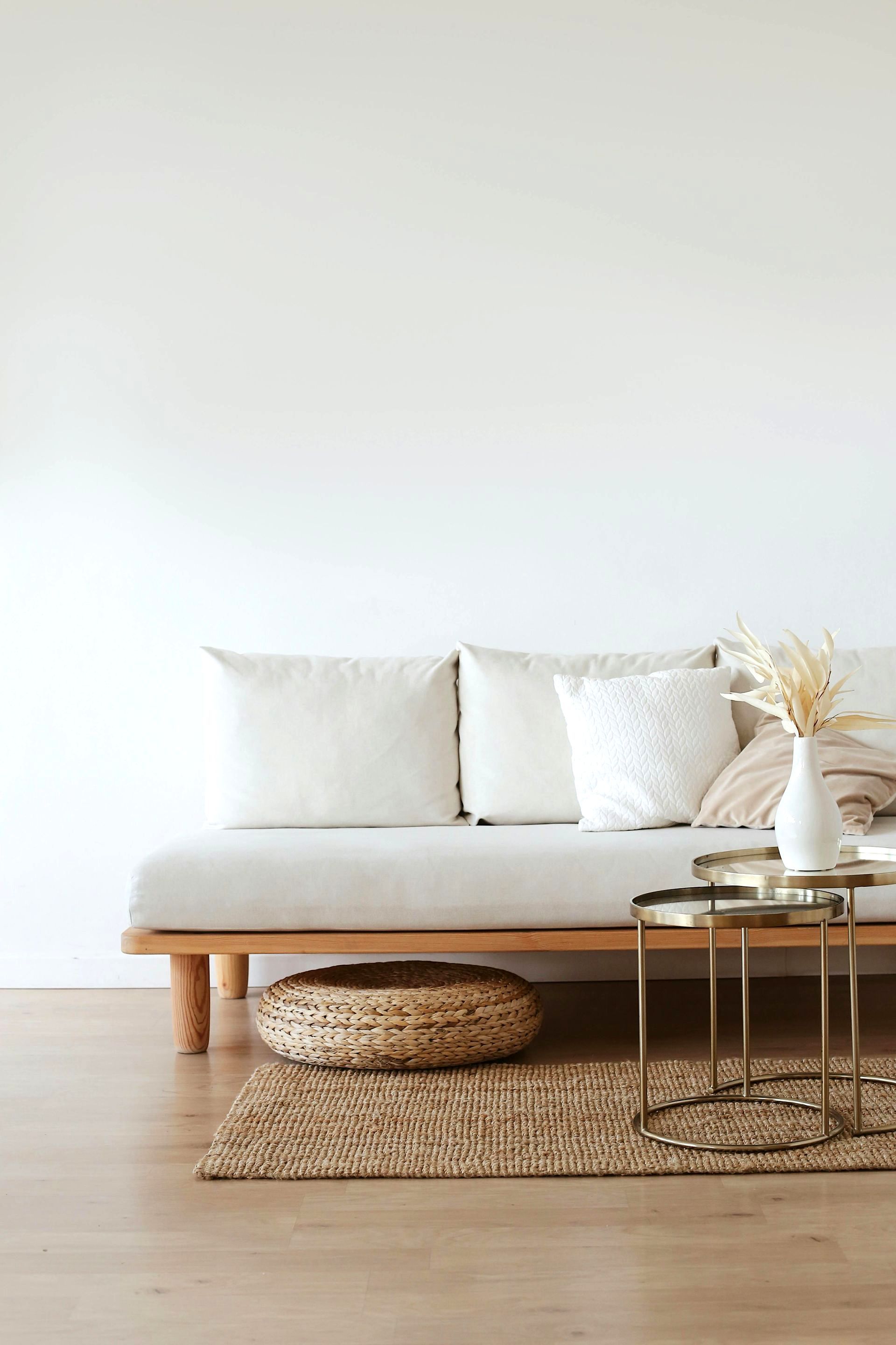 A living room with a couch , two tables , and a rug.