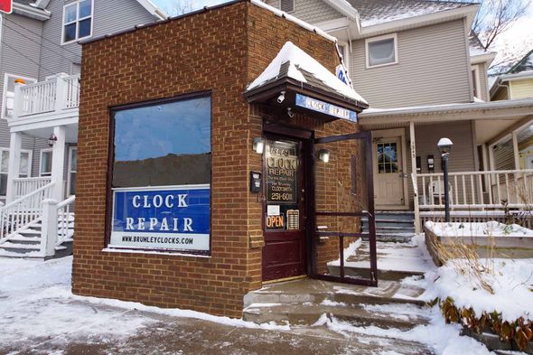 A brick building with a sign that says clock repair — Madison, WI — Brumley's Old Clock Shop