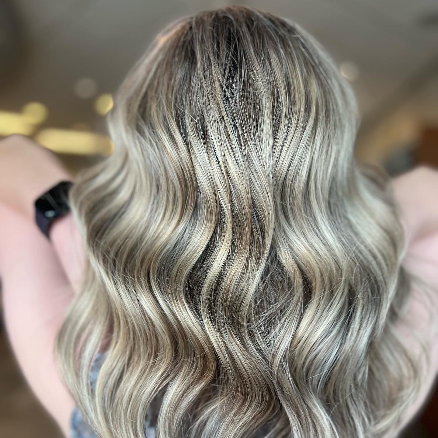 Woman's Hair The back of a woman 's head with long wavy blonde hair.