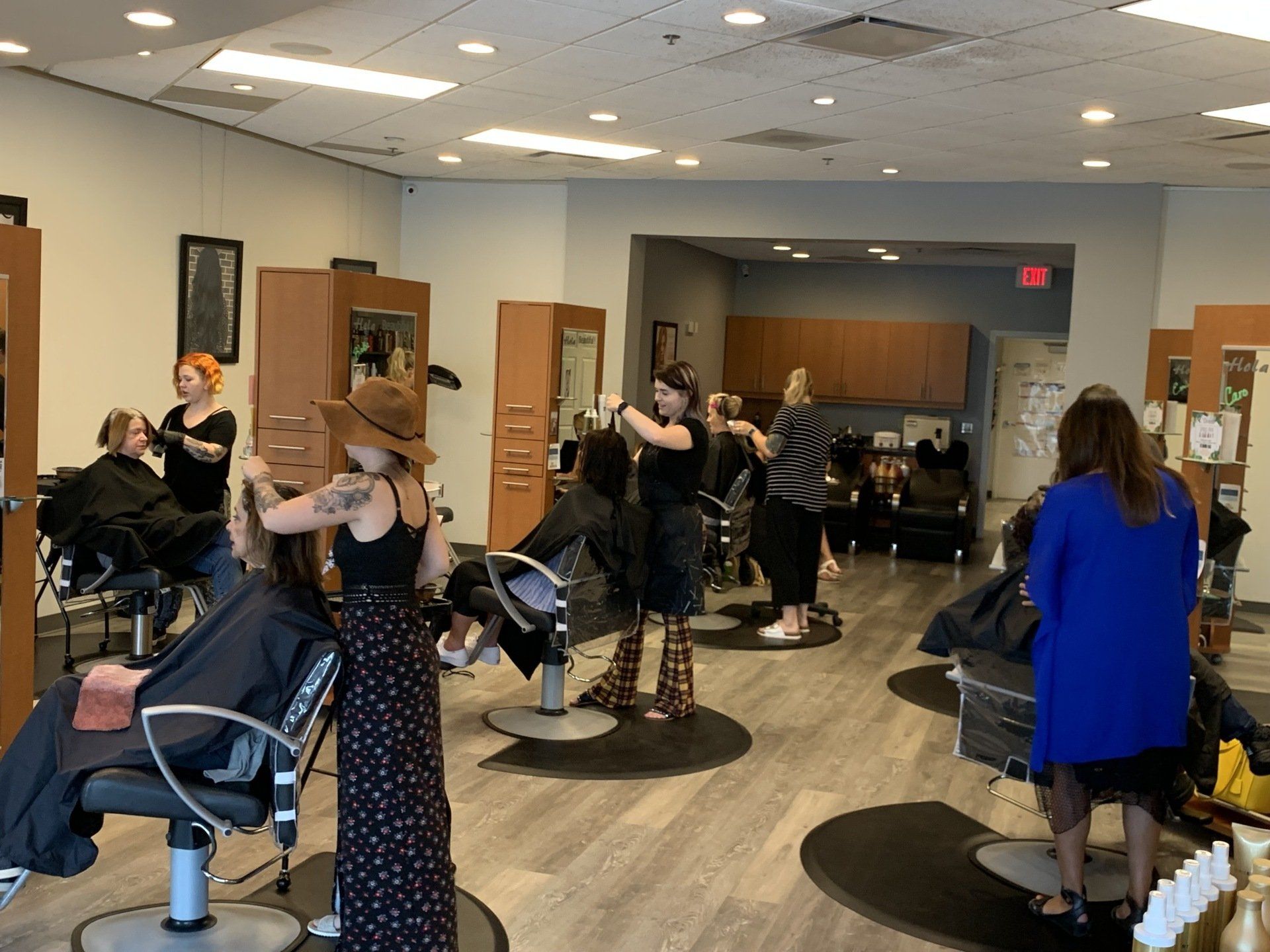 A group of women are getting their hair cut in a salon.