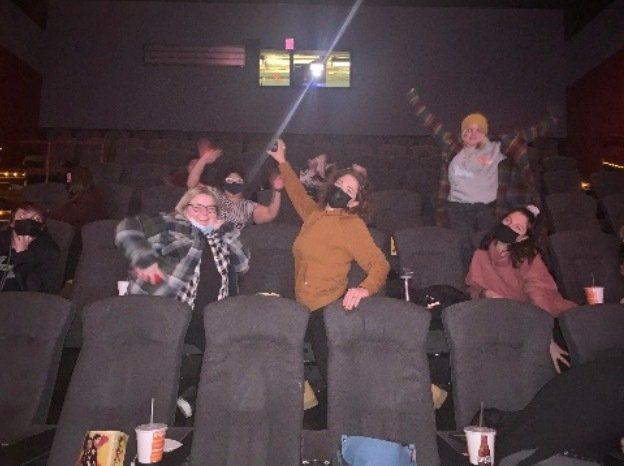 A group of people are sitting in a theater watching a movie