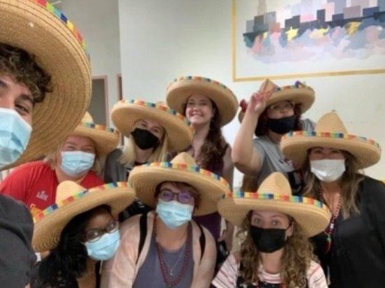 A group of people wearing sombrero hats and face masks