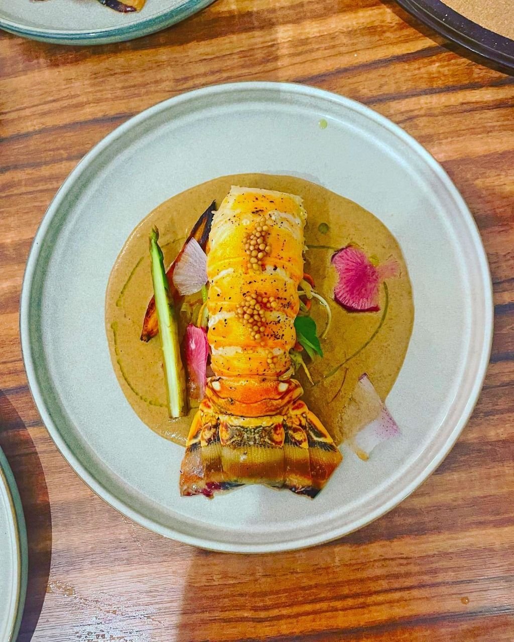 A bowl of food is sitting on a wooden table.
