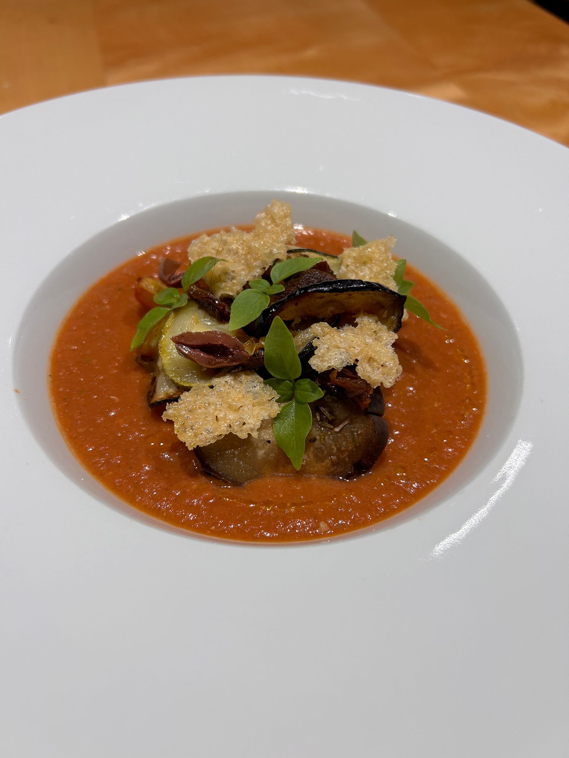 A close up of a bowl of soup with vegetables on top