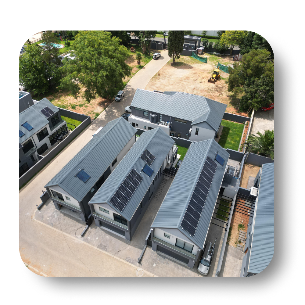 Aerial view of gray-roofed modern homes with solar panels in a residential neighborhood.