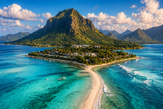 Tropical island with a central mountain, turquoise water, and a sandy spit under blue skies