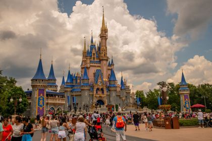 Cinderella Castle at Disney World with crowds of visitors under a cloudy sky