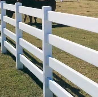 White wooden fence beside a grassy yard in daylight
