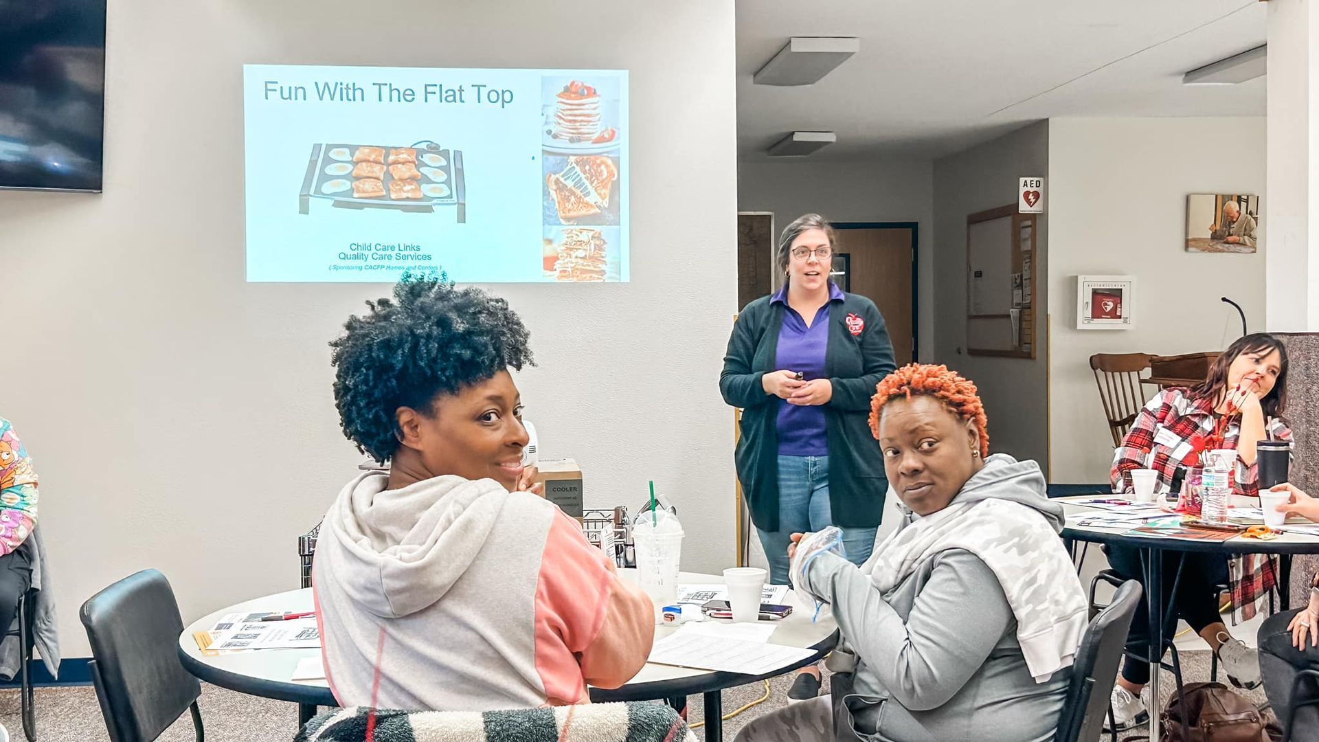 A group of women are sitting at tables in a room.