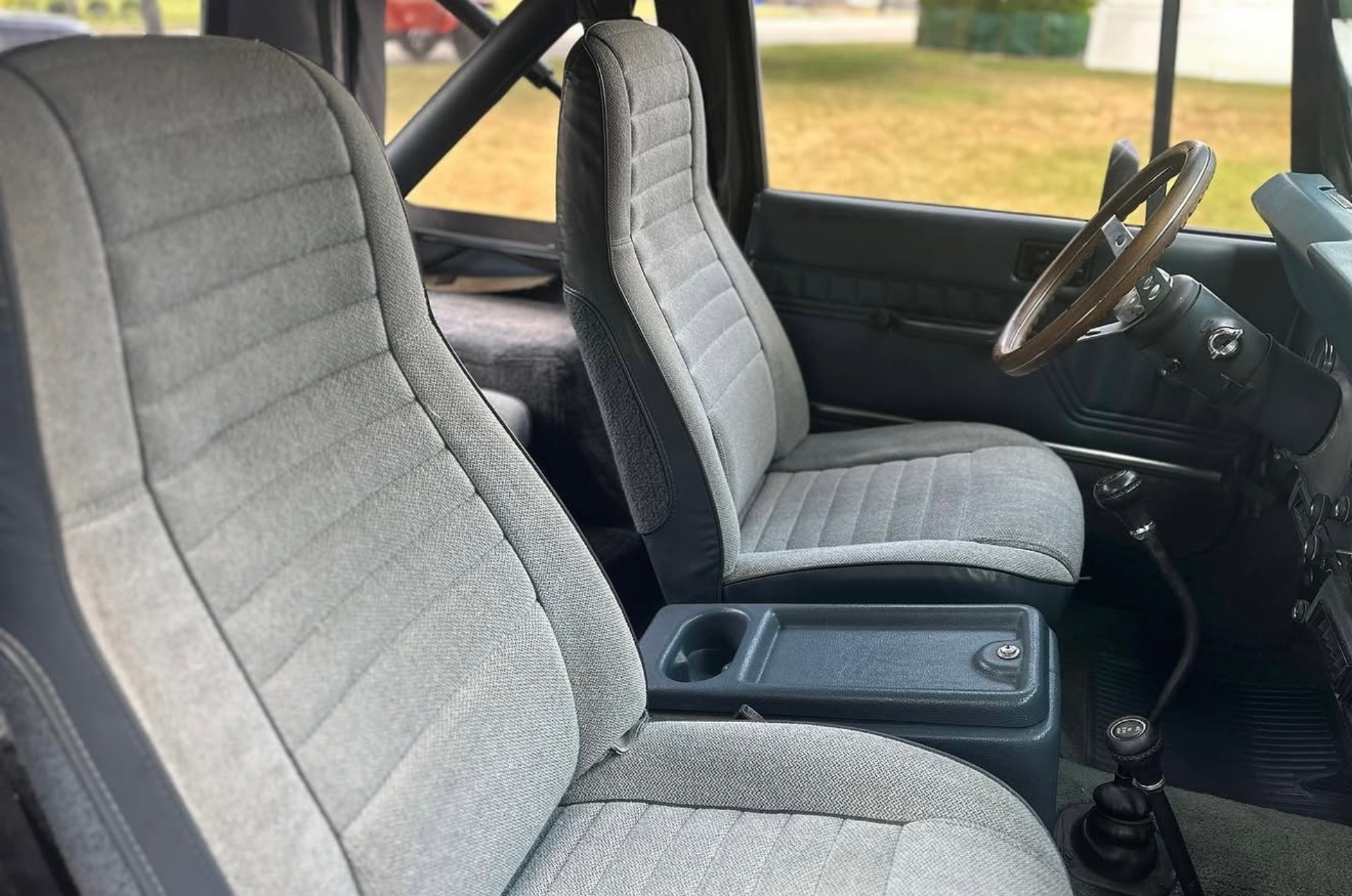 Car interior with a gray front passenger seat and center console in dark upholstery.