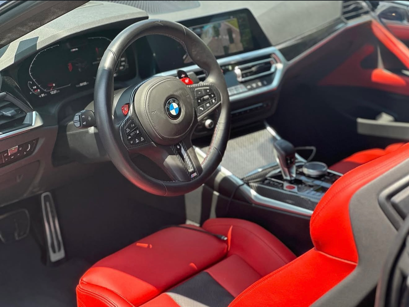 BMW sports car interior with red seats, black dashboard, and steering wheel view