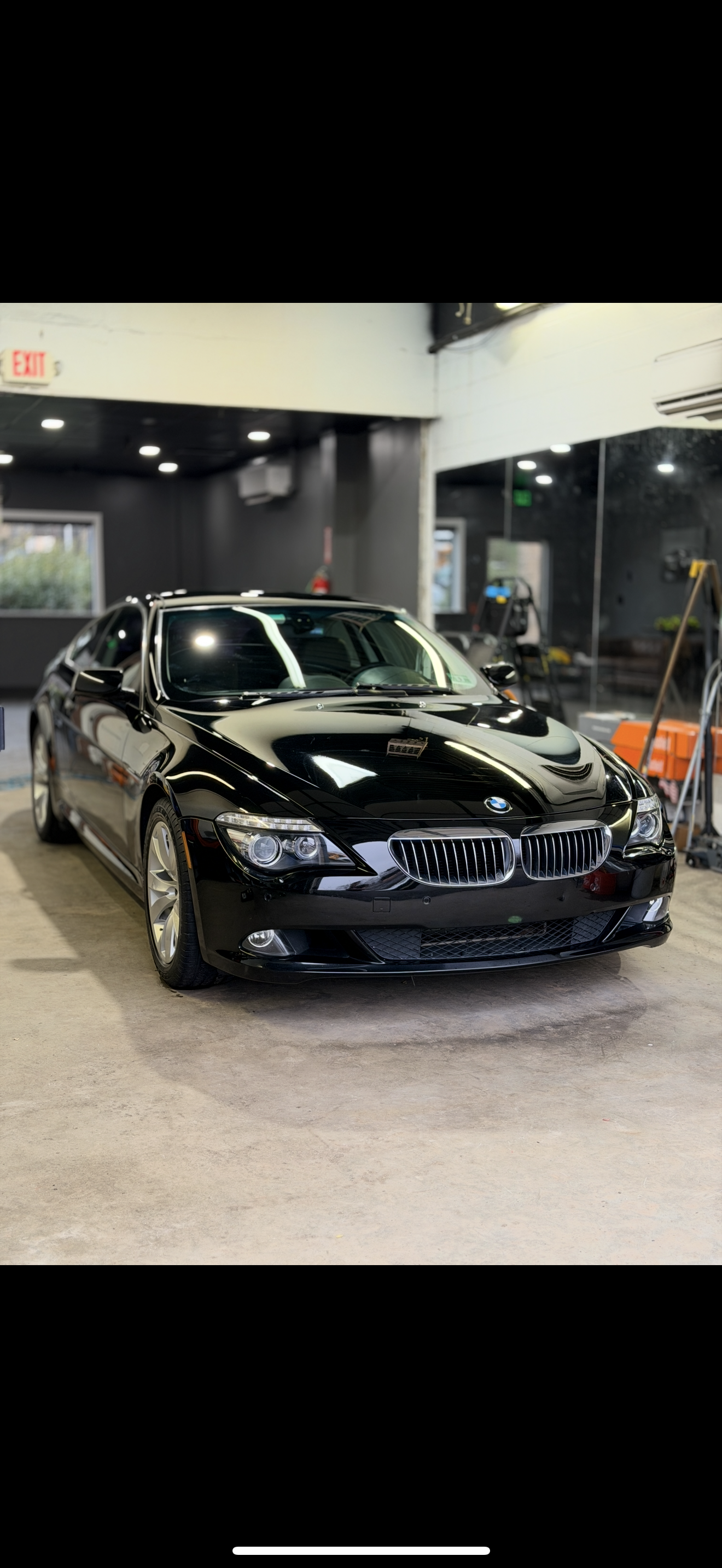 Black BMW sedan displayed indoors under showroom lights