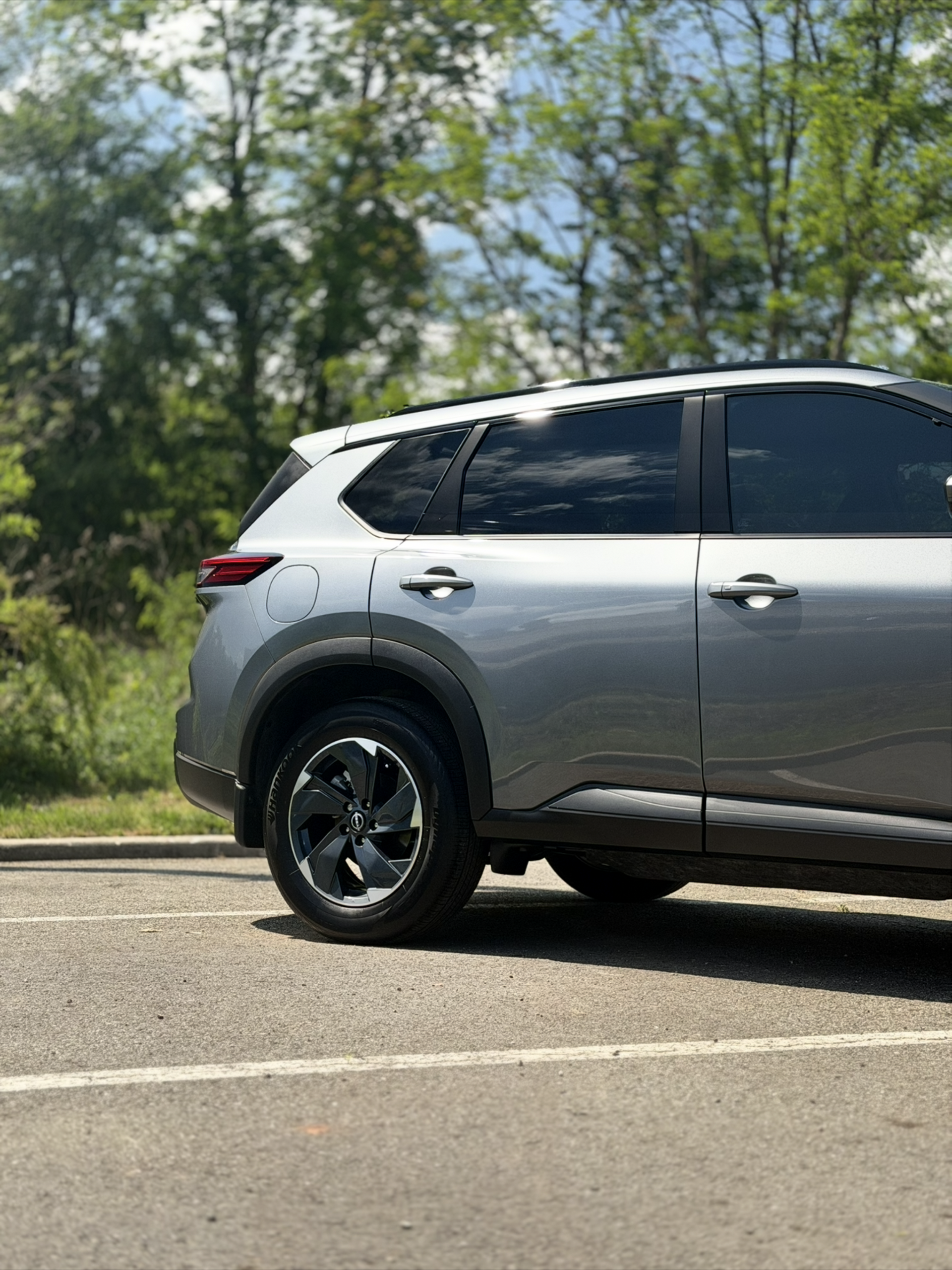 Silver SUV parked on a roadside with trees in the background