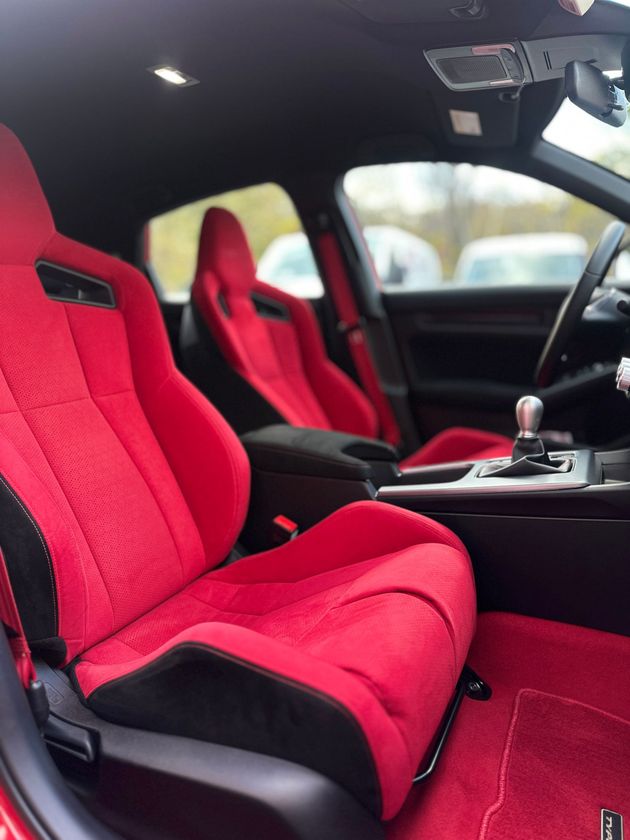 Red bucket seats with black accents inside a car interior