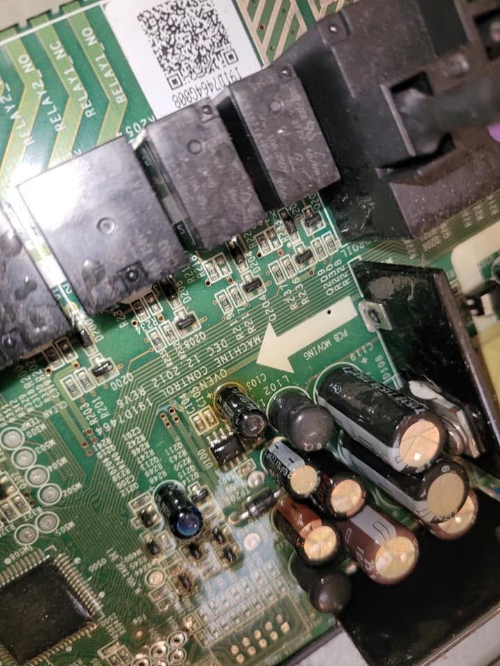Close-up of a green circuit board with black connectors and several capacitors