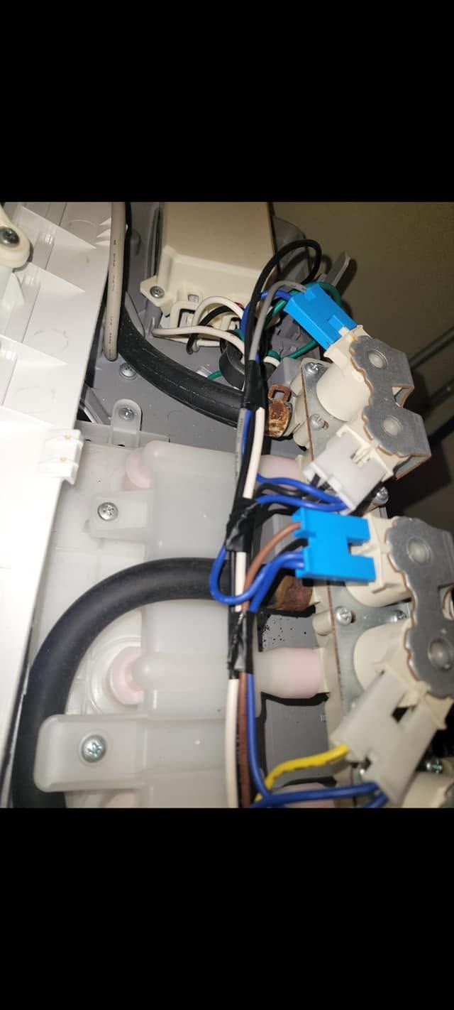 Close-up of blue wires and electrical connectors inside a machine compartment