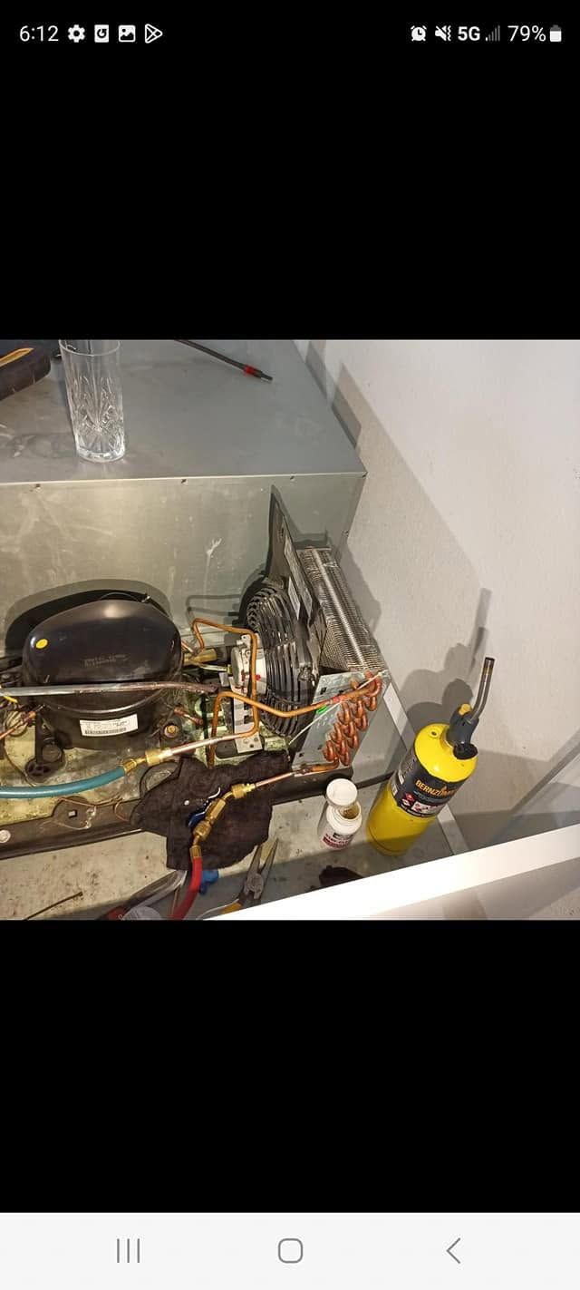Cluttered kitchen sink area with dirty dishes, cookware, and cleaning supplies on the counter