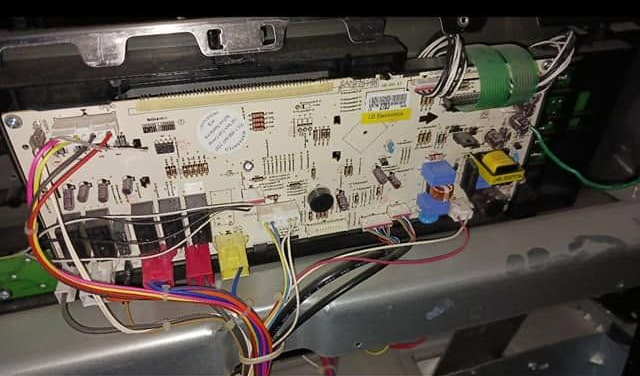 Close-up of a circuit board with wires and connectors inside an electronic device.