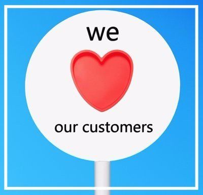 Sign reading “we love our customers” with a red heart on a blue background