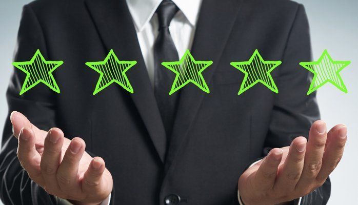 Businessman holding glowing green star ratings above open hands