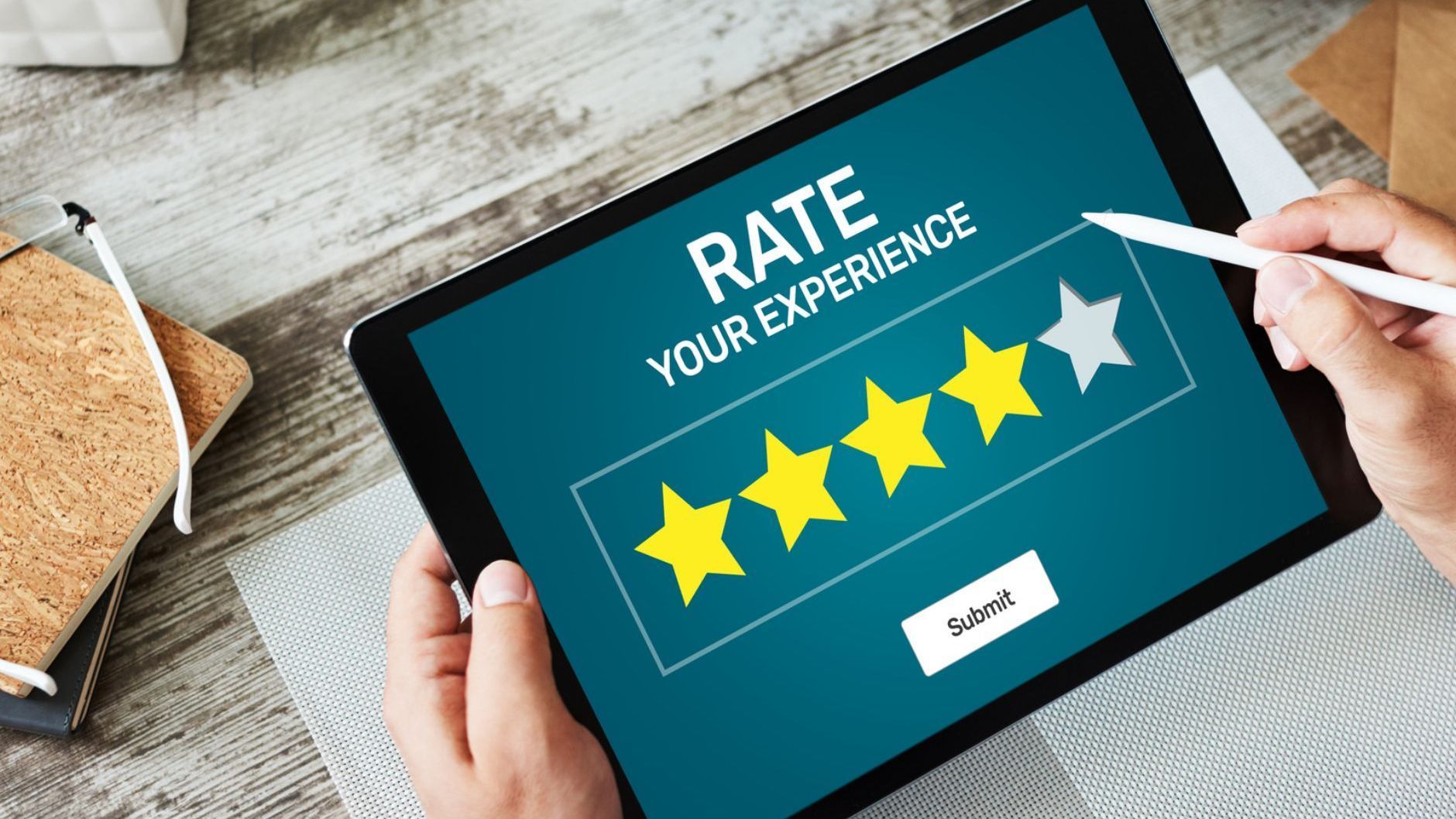 Tablet showing a 5-star rating screen with a hand tapping stars on a table