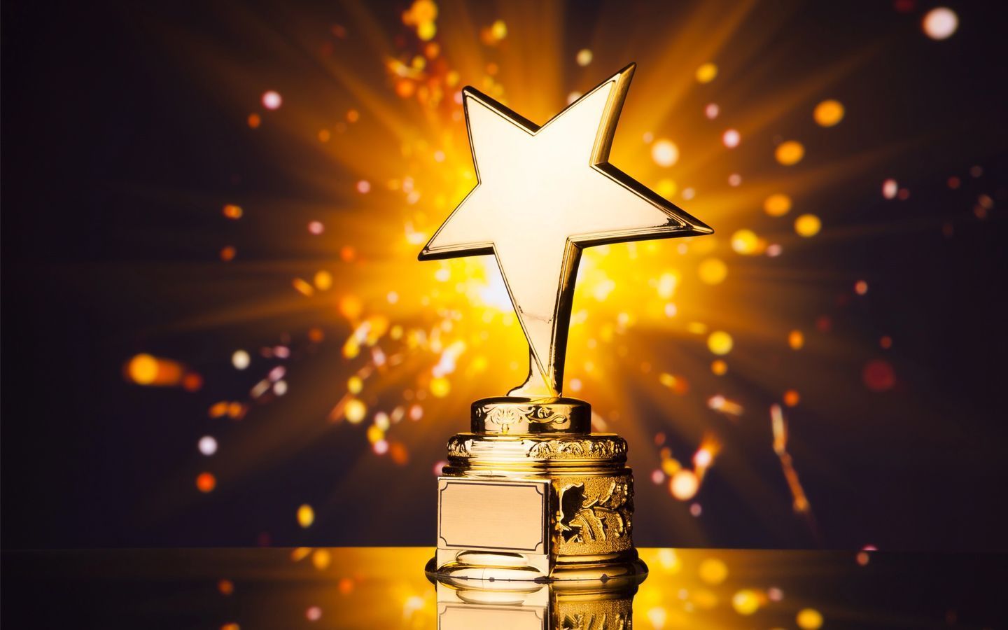 Golden trophy with a star-shaped top against a glowing orange background