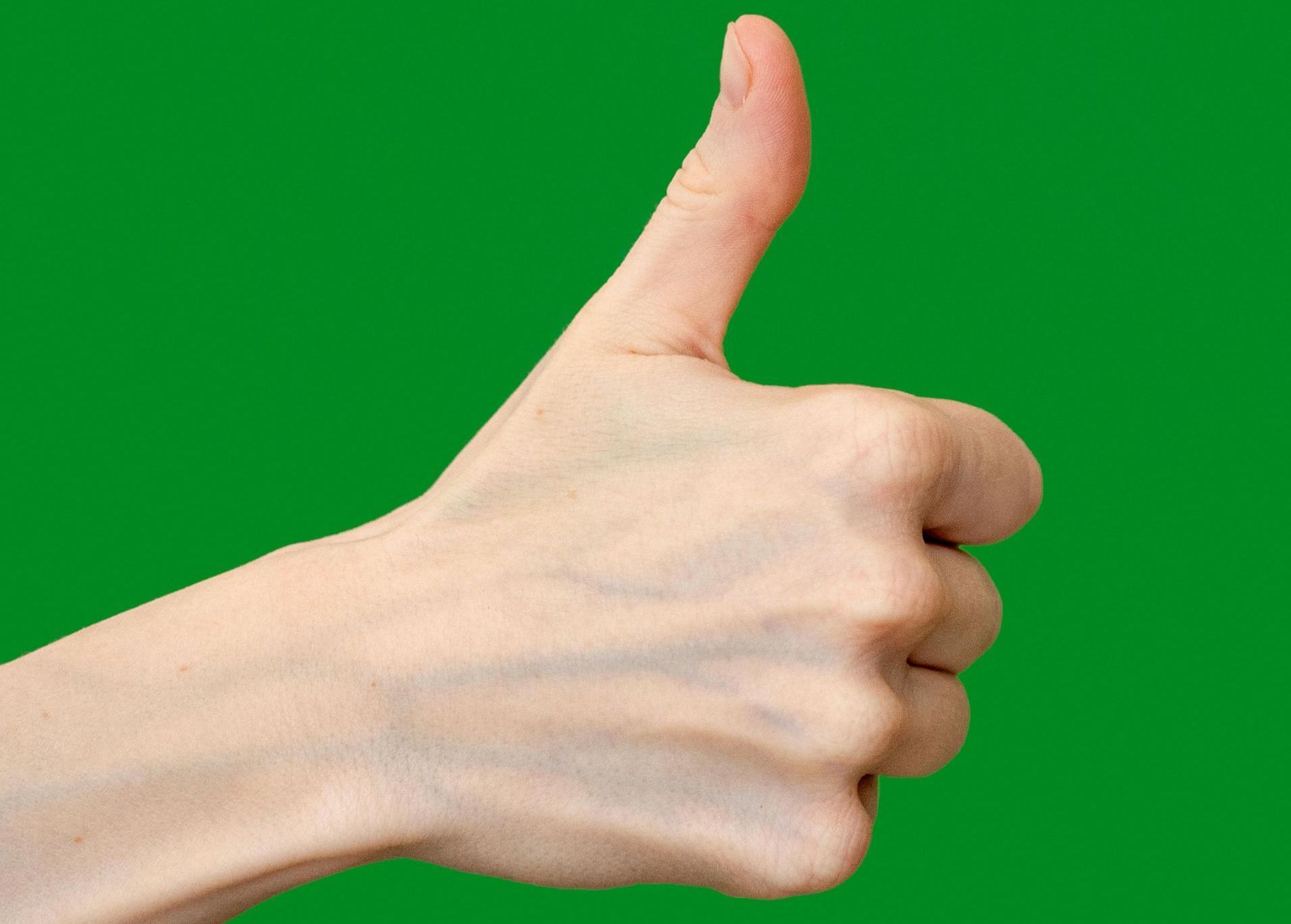 Hand giving a thumbs-up against a bright green background