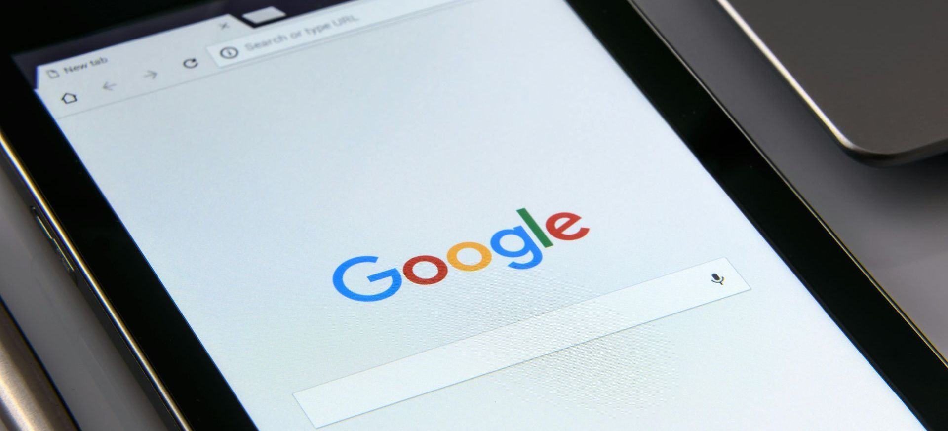 Google homepage displayed on a tablet with a white screen and search bar