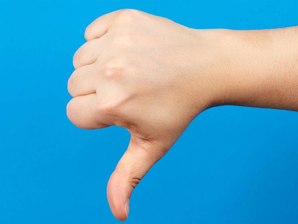 Hand showing a thumbs-down gesture against a blue background