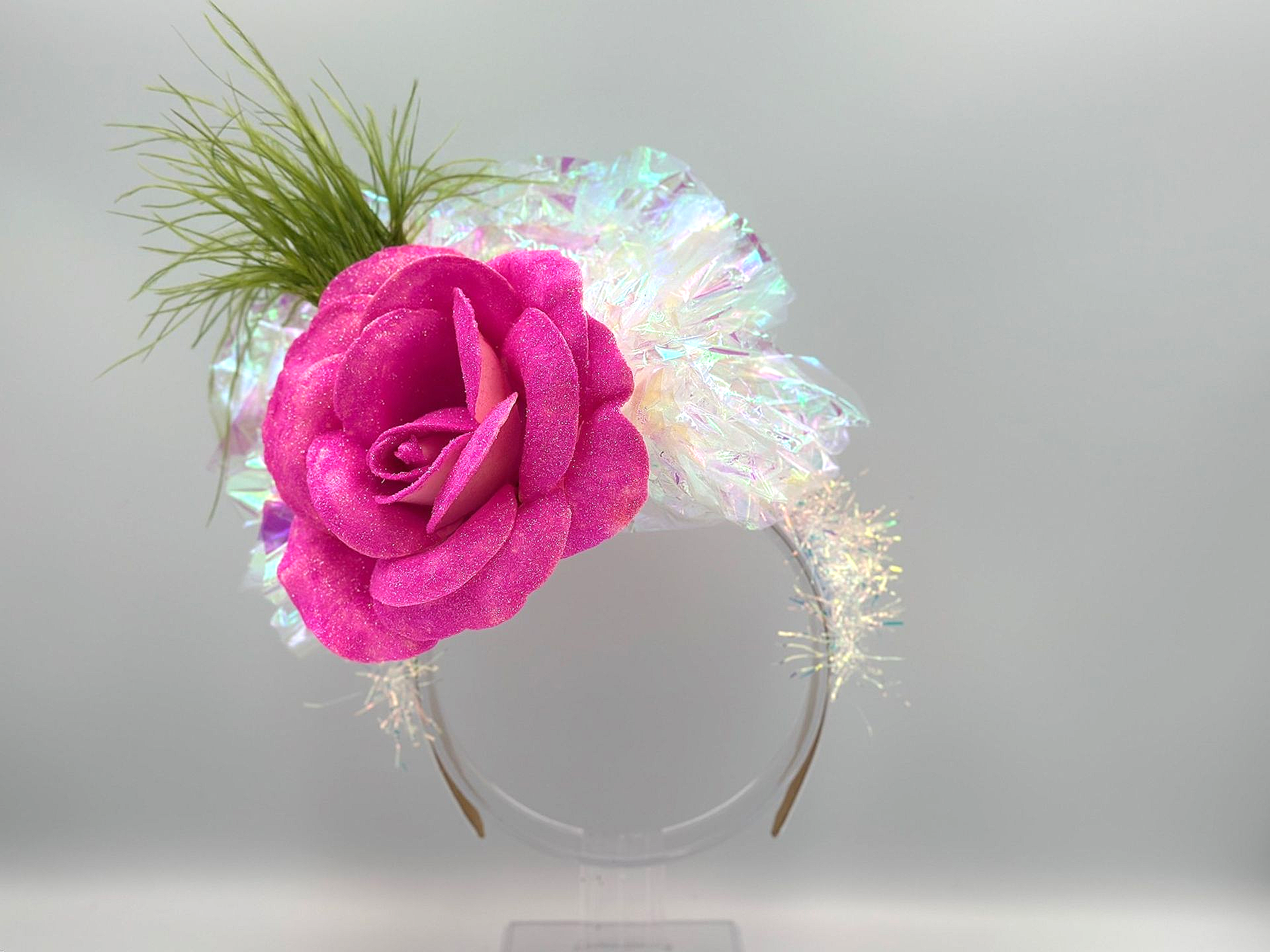 Pink glitter rose and iridescent accents on a gold headband.